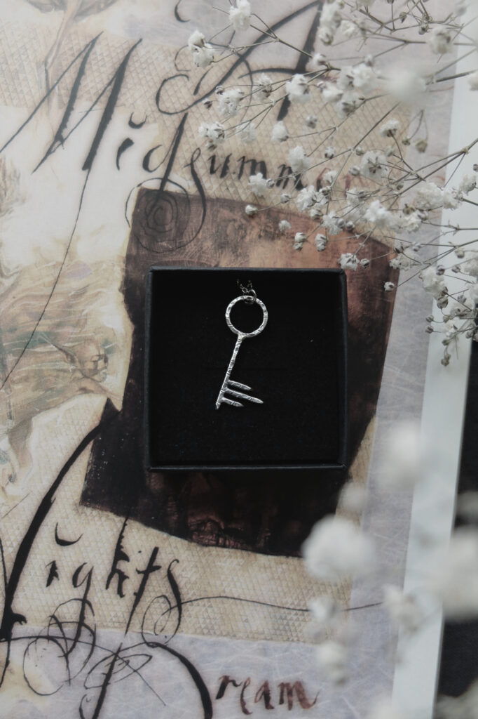 distressed silver key pendant on a Dave McKean calligraphy of "A Midsummer Nights Dream"