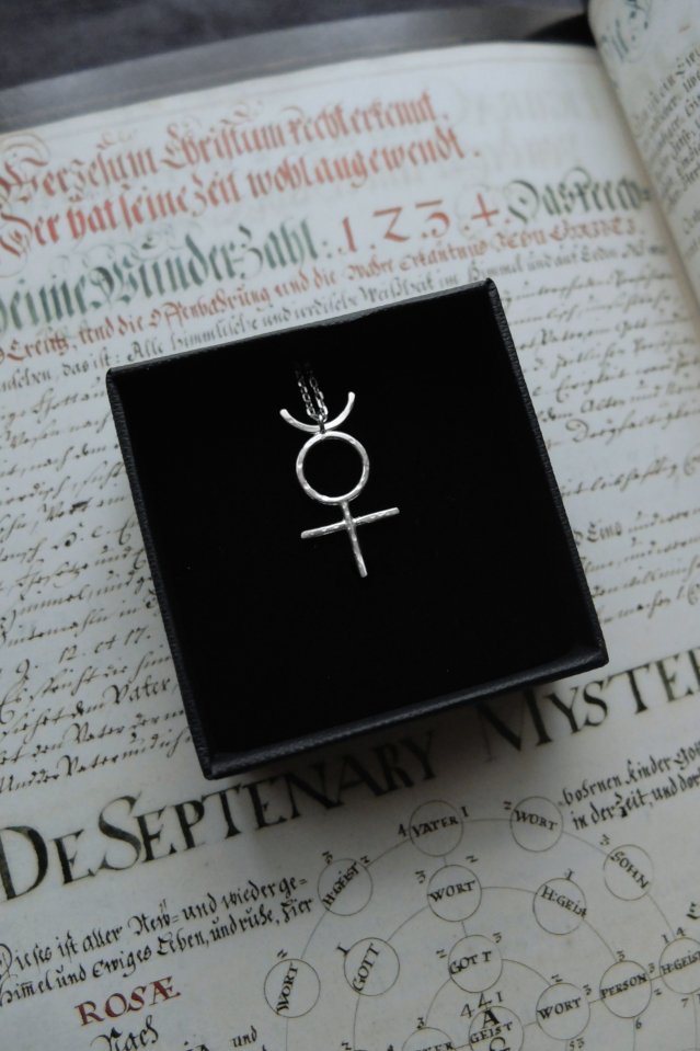 silver pendant of the alchemical symbol Mercury