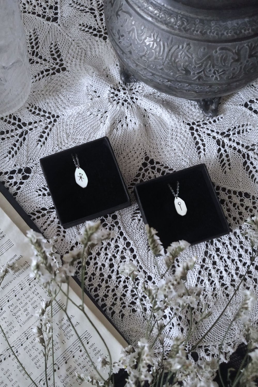Silver Runic amulets with love Bind-Rune and Sol medieval rune on a doily